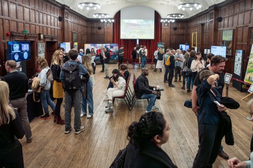 People in a room looking at exhibits at a research showcase